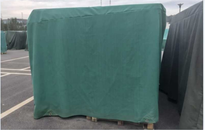 Warehouse interior showing over 20,000 pallets stacked densely and completely covered by blue tarpaulins, hiding product identification from visual line of sight.