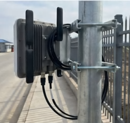 Laptop showing a remote technical support video call, with a warehouse worker following FYJ's online instructions to position an RFID reader on a support pole.